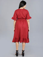 Woman wearing a red dress with ruffled sleeves and hem on a gray background